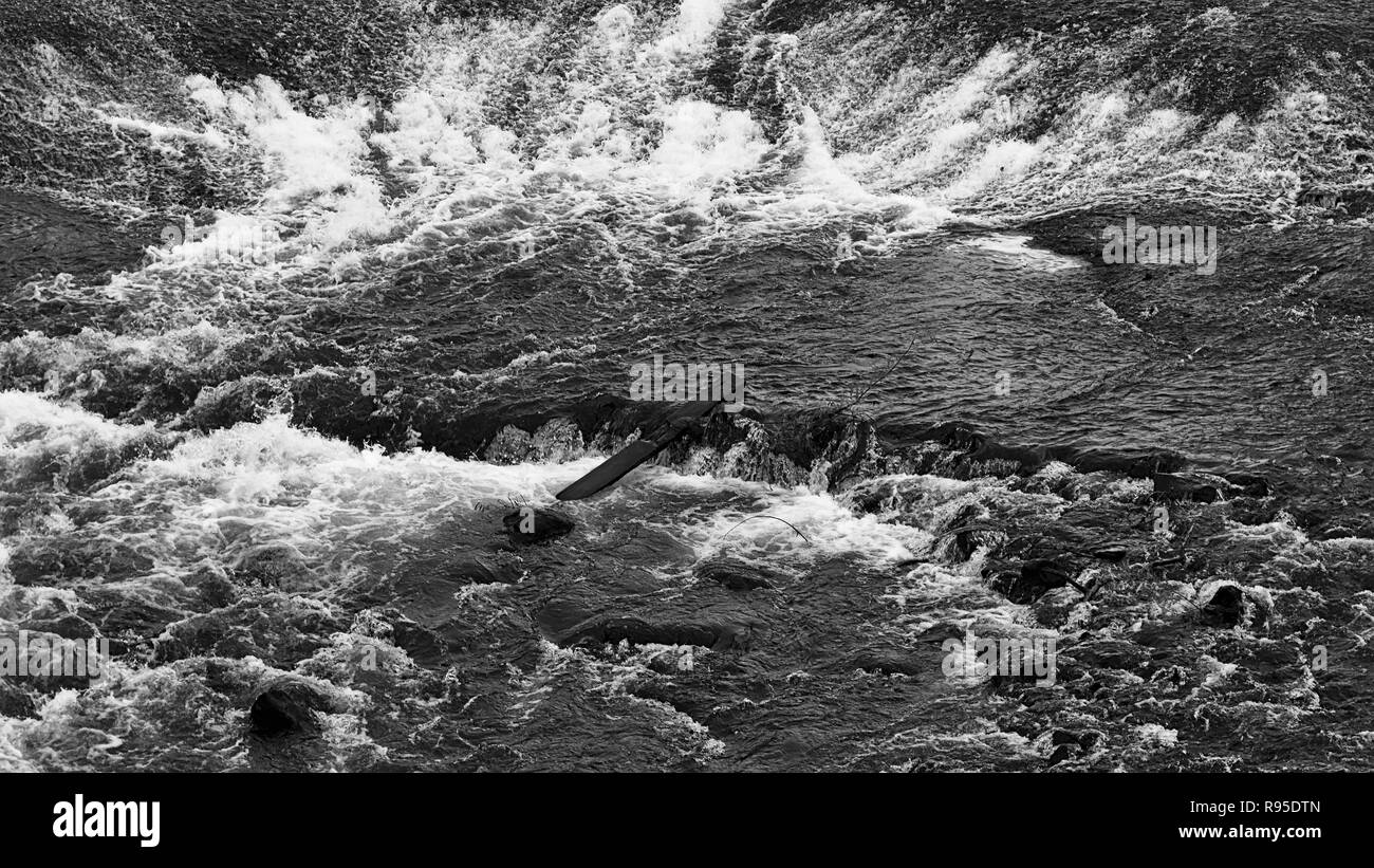Río que fluye sobre rocas provocando rápidos Foto de stock