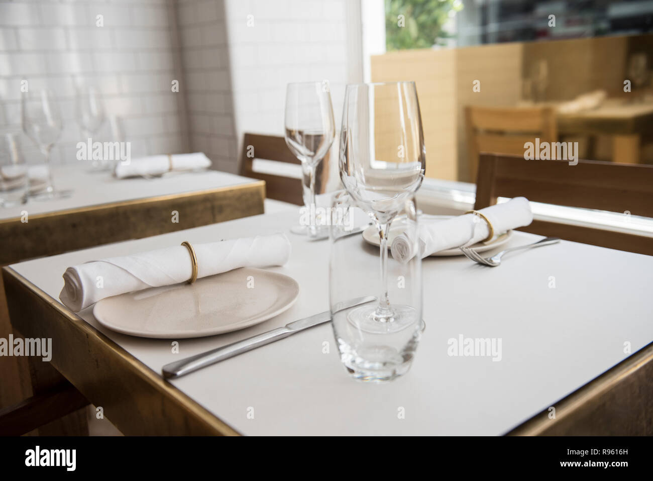 Una mesa de comedor es visto preparadas para los clientes. La tabla está  vacía, pero los bellos platos y vasos de cerámica se ve muy sofisticado  Fotografía de stock - Alamy