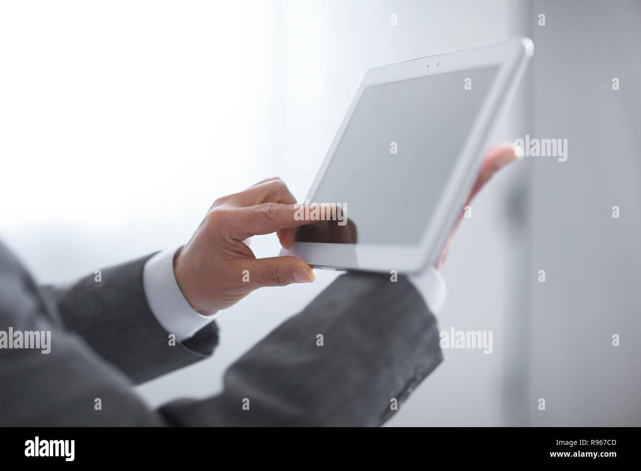 Cerca. una mano de hombre presiona la pantalla de una tableta digital Foto de stock