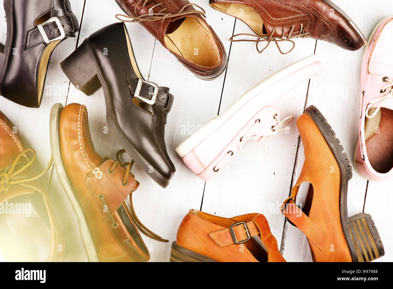Conjunto de diferentes zapatos unisex sobre fondo blanco de madera  Fotografía de stock - Alamy