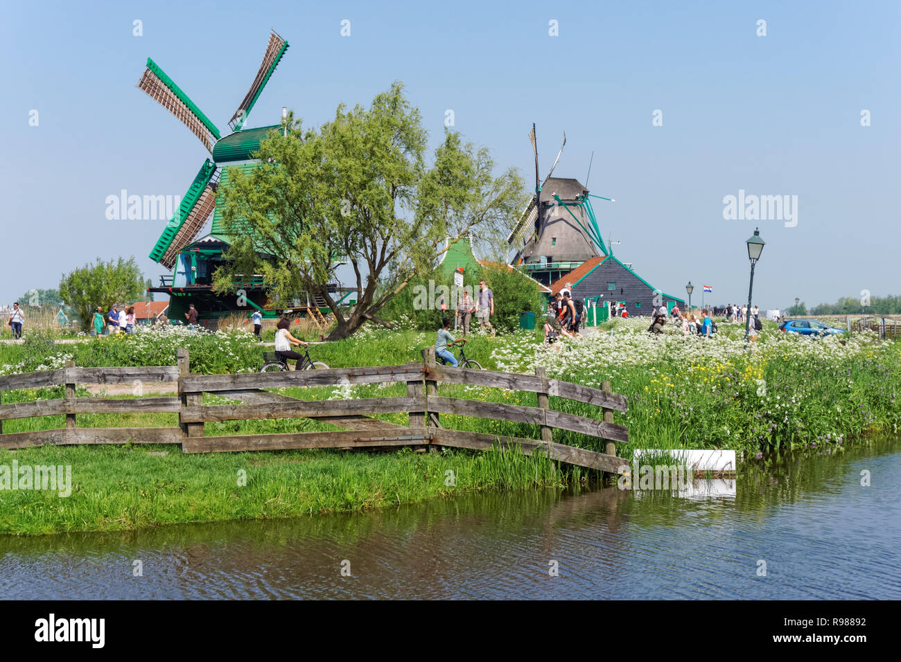 Los turistas que caminan a lo largo de los molinos de viento tradicionales holandeses en Zaanse Schans en Holanda Foto de stock