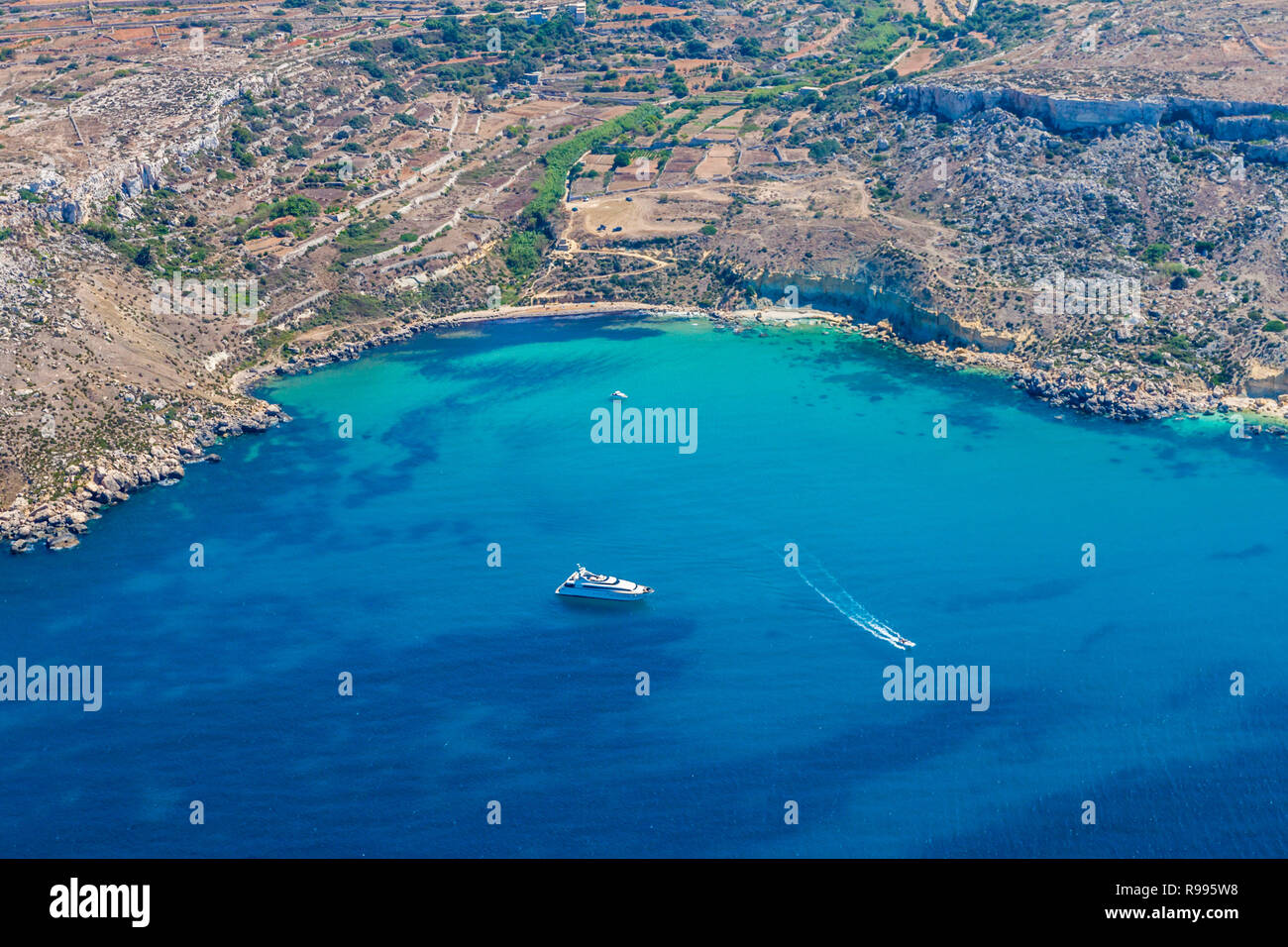Bahía Mgiebah, calas solitarias accesible por un camino rocoso, con una pequeña playa de arena y azul agua azul turquesa. Mellieha, Malta. Foto de stock