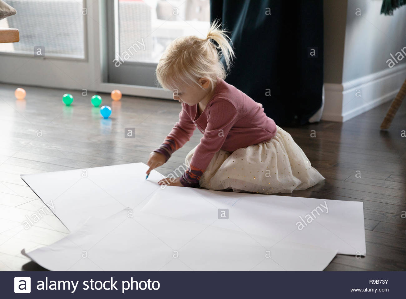 Linda chica dibujo, colorear en el piso Foto de stock