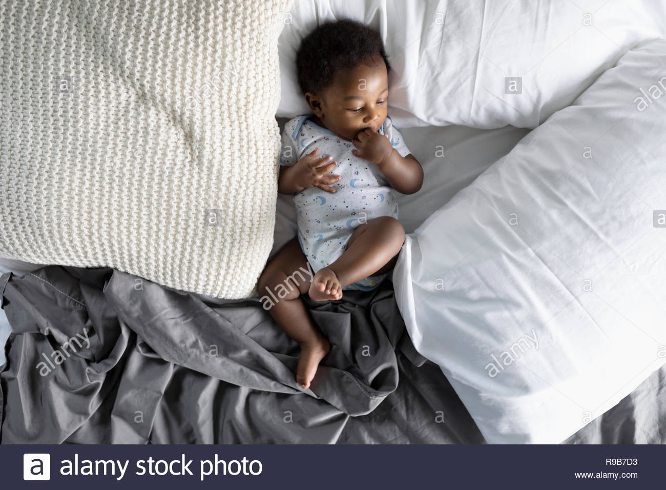 Vista desde arriba cute Baby Boy sentando en la cama Foto de stock