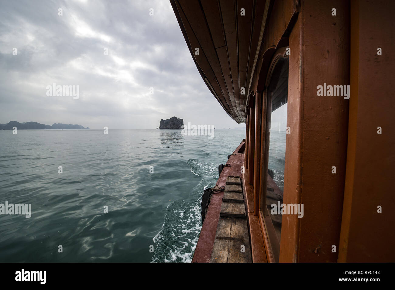 Un barco de turistas está navegando en las aguas de la bahía de Ha Long en Vietnam. Foto de stock