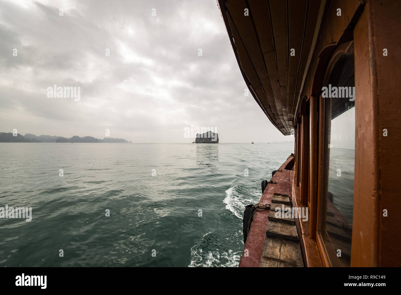 Un barco de turistas está navegando en las aguas de la bahía de Ha Long en Vietnam. Foto de stock