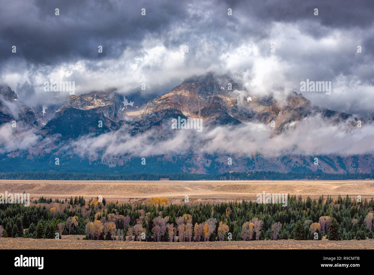 La Teton Mountains en un lluvioso día de otoño con una gruesa capa de nubes bajas por debajo de los picos Foto de stock