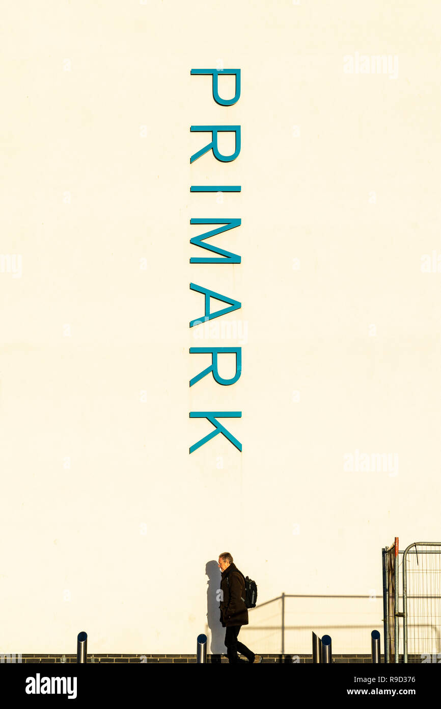 Primark vertical grande firmar en el lateral del edificio edificio blanco  con el hombre solitario con mochila caminando por debajo Fotografía de  stock - Alamy