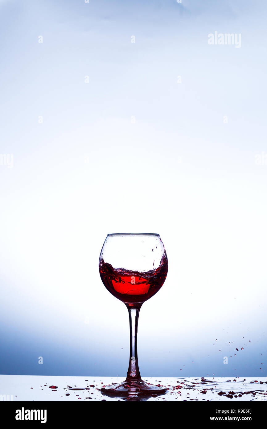 Salpicaduras de vino en vidrio, acrílico, iluminación de estudio de fondo Foto de stock