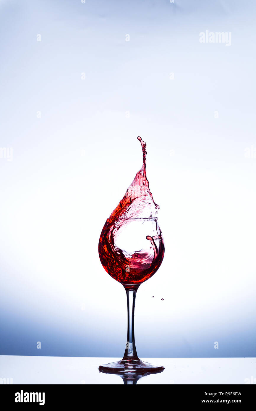 Salpicaduras de vino en vidrio, acrílico, iluminación de estudio de fondo Foto de stock