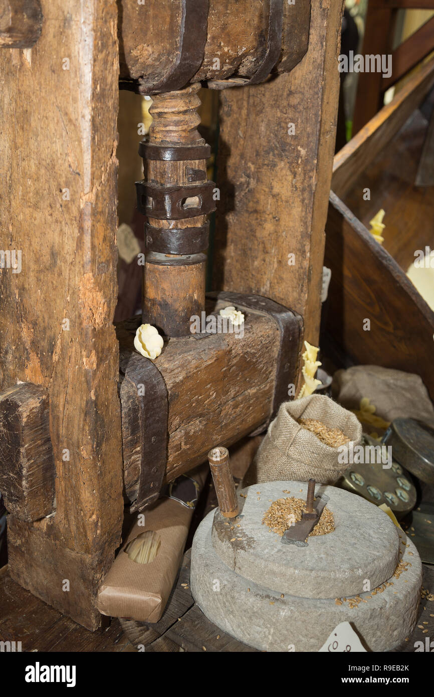 Antiguo molino de piedra: amoladora manual con la manivela y la rueda de  prensa de madera para pasta Fotografía de stock - Alamy