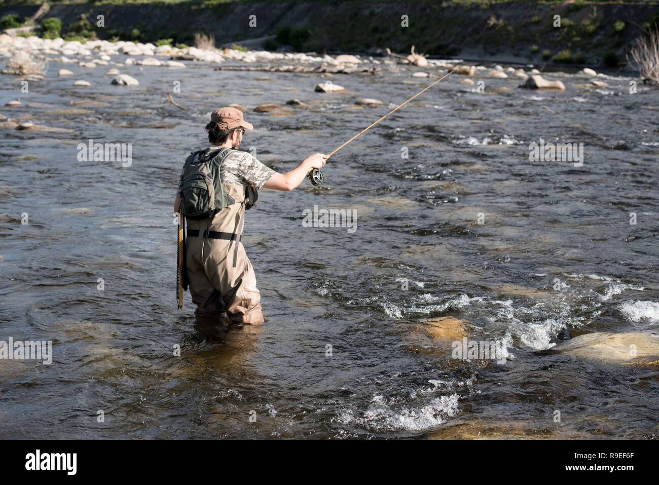 Aubenas (sureste de Francia): el pescador con mosca en el río Ardèche proyectando su caña de pescar. Foto de stock