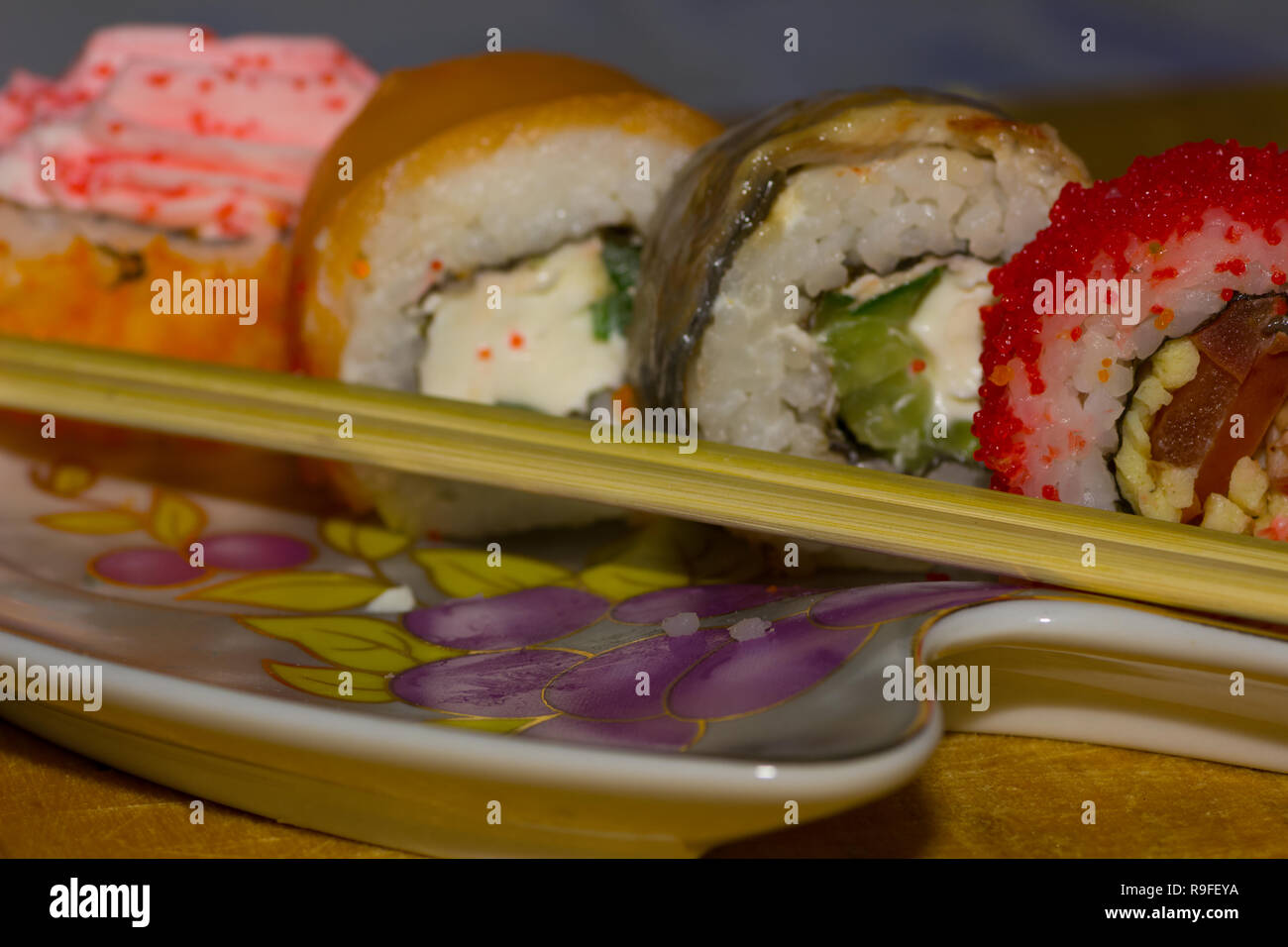 Rollos de sushi con salmón, anguila, queso crema Philadelphia, caviar tobica y la comida se pega en la placa Foto de stock