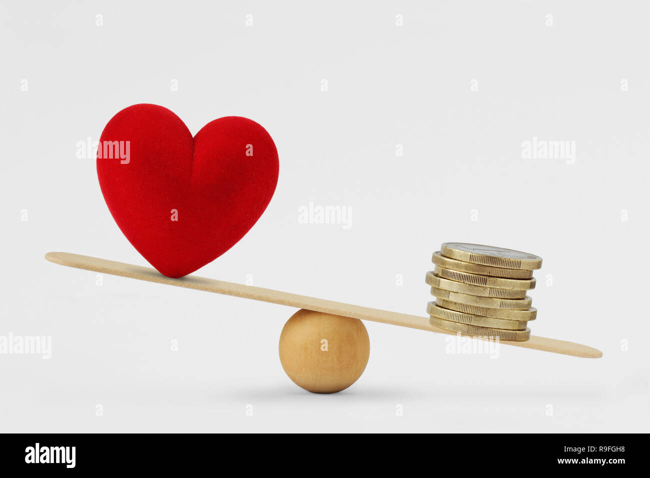 El corazón y el dinero en la balanza - Concepto de dinero la prioridad en la vida Foto de stock