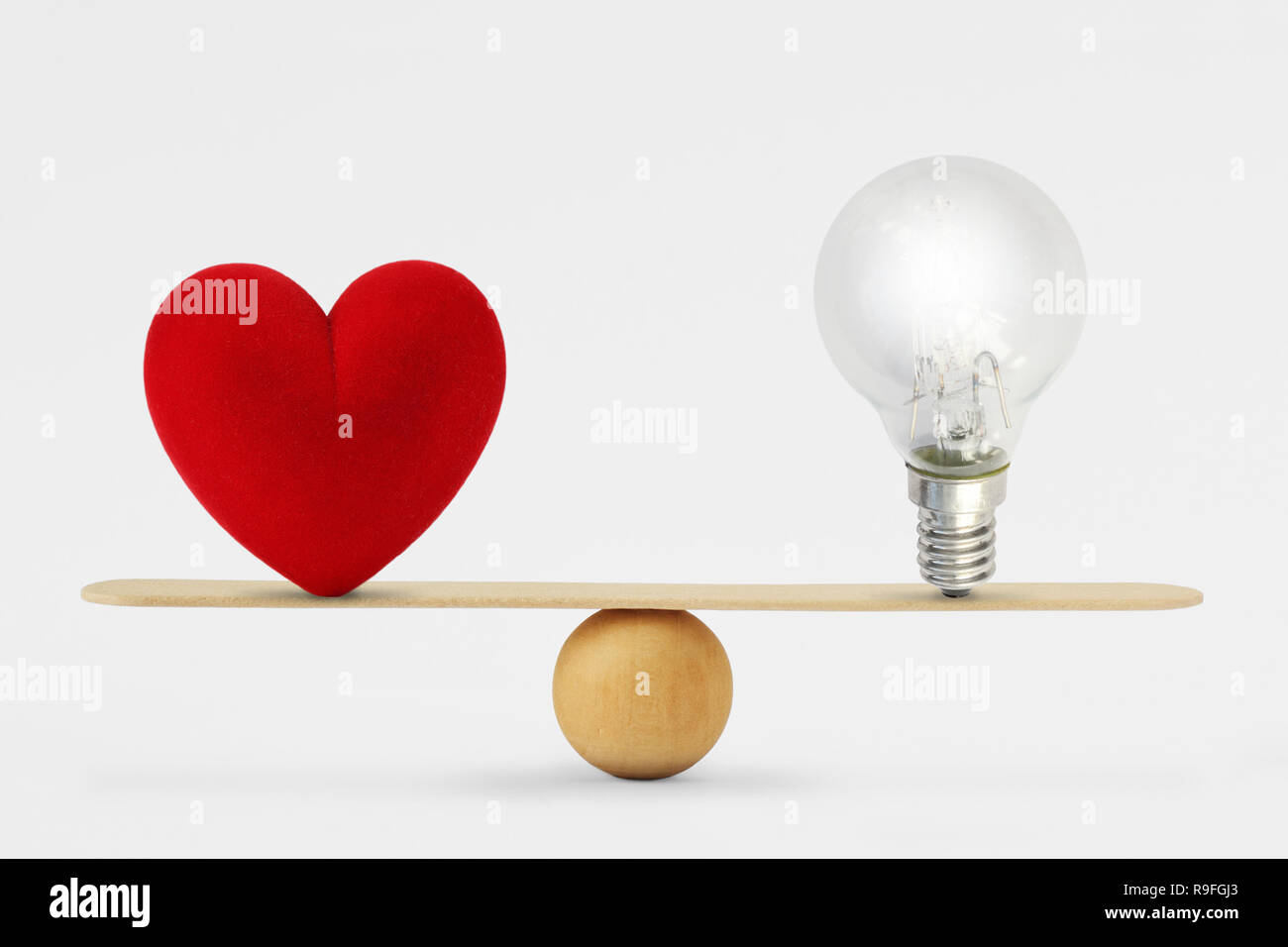 Corazón y la bombilla en la escala - Concepto de equilibrio entre el corazón y el cerebro Foto de stock