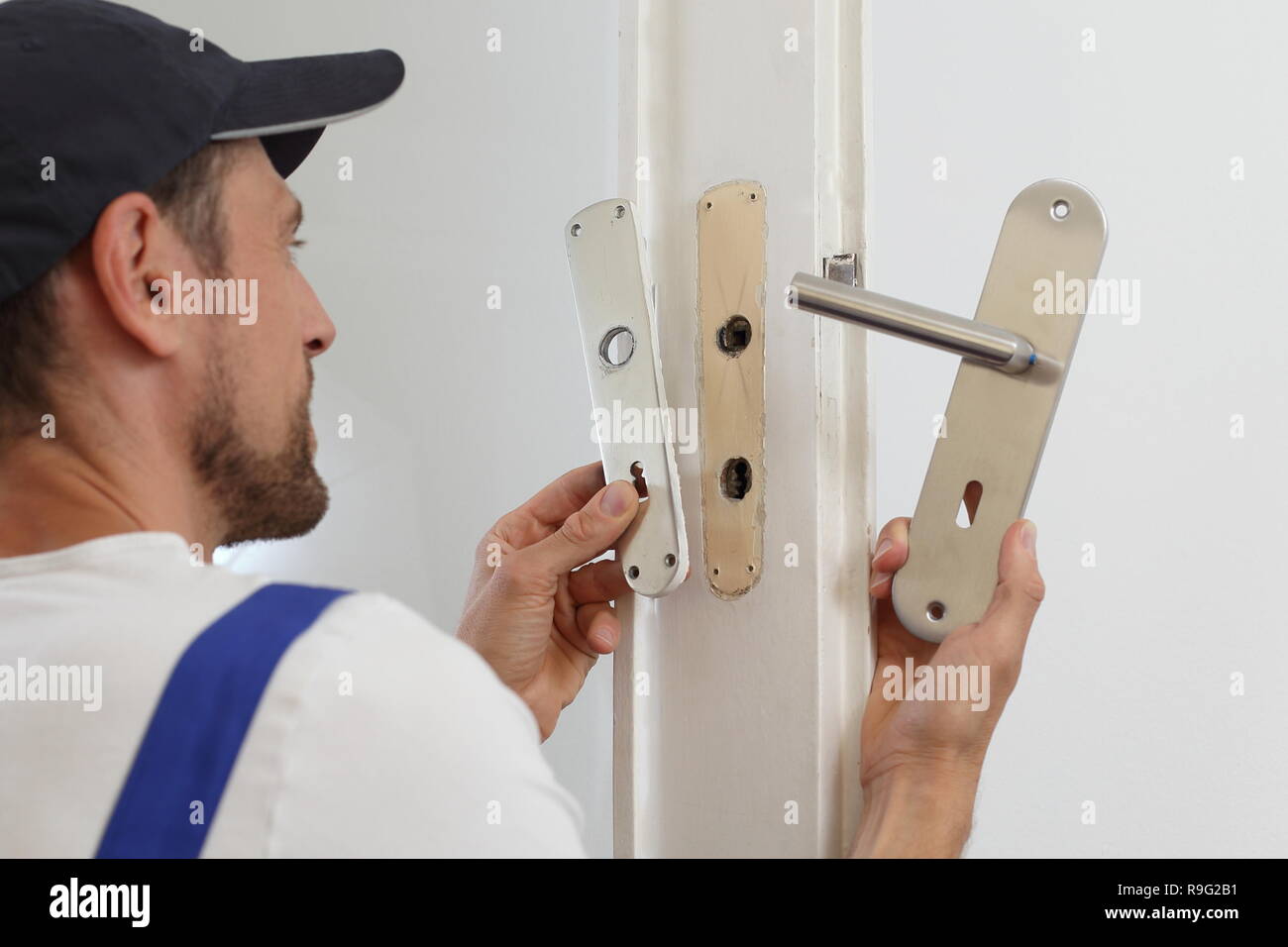 Un hombre sustituir una empuñadura de puerta Foto de stock