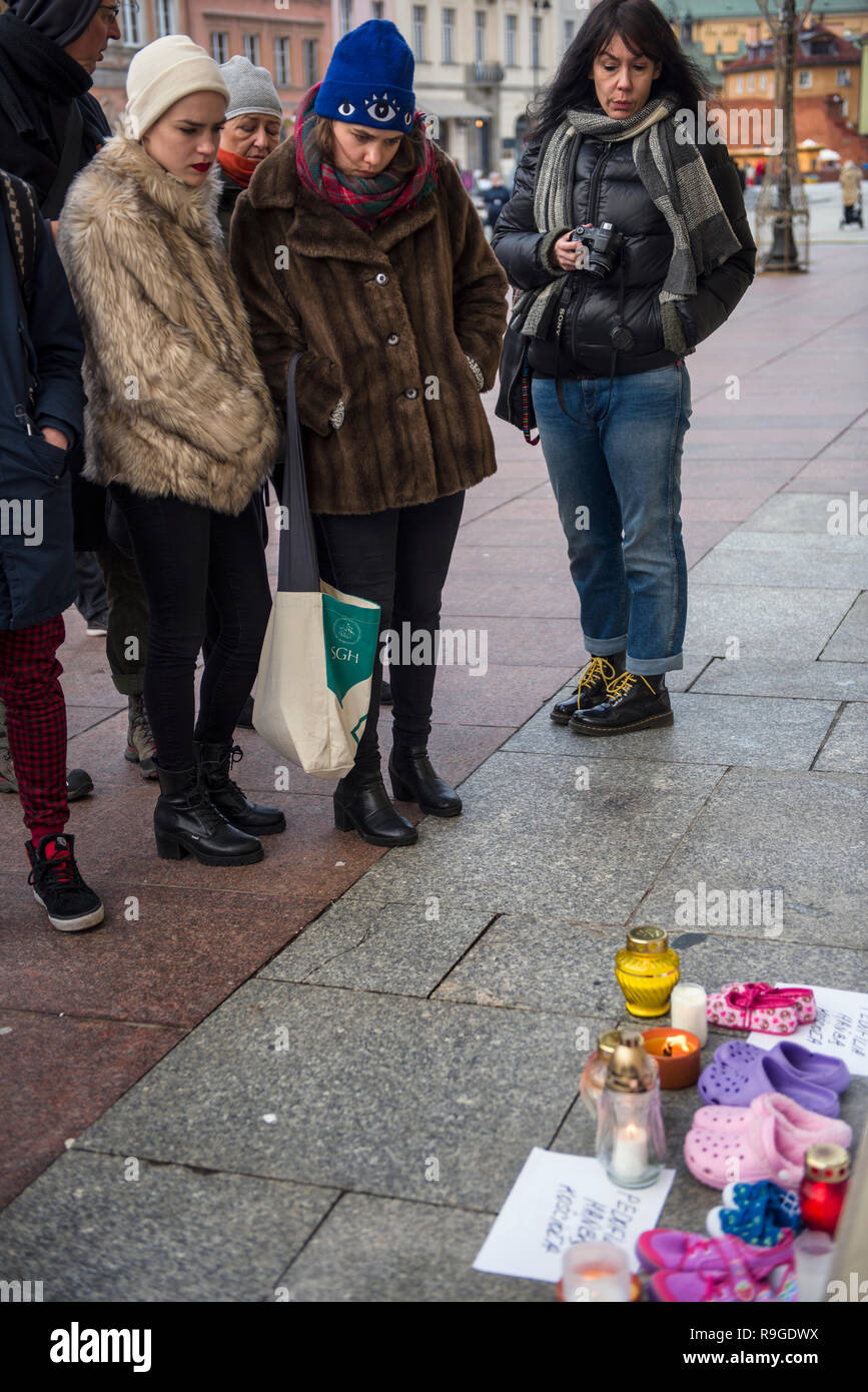 Varsovia, Polonia. 23 Dec, 2018. Los manifestantes son vistos de pie  mientras mira los zapatos, velas y pancartas durante la protesta. La huelga  nacional de Mujeres (Strajk Ogólnopolski Kobiet) organizó la campaña