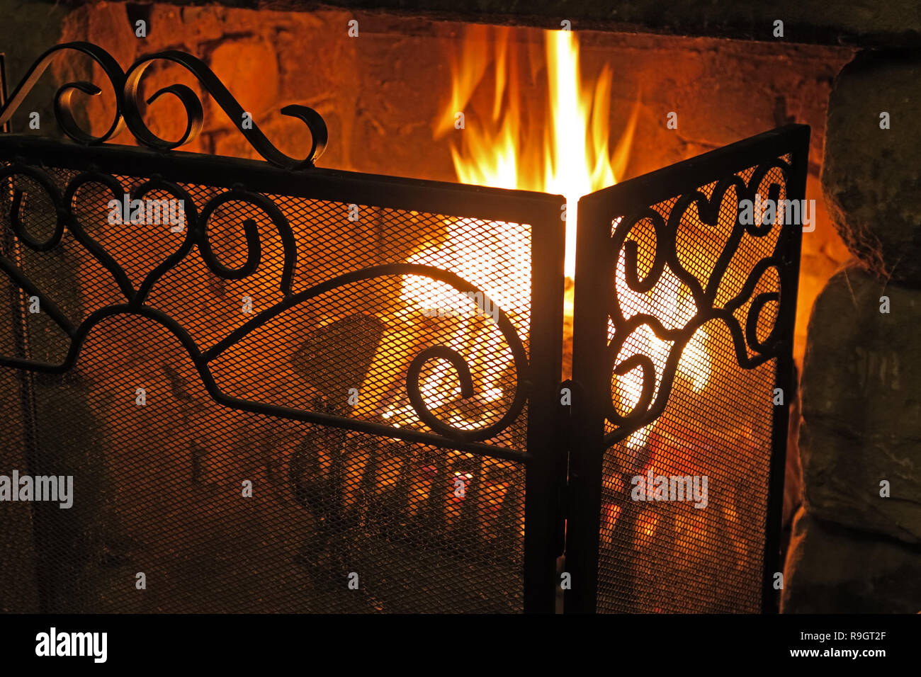 Las llamas de un incendio real, en una reja de hierro fundido, tiempo de invierno, precioso naranja cálido resplandor Foto de stock