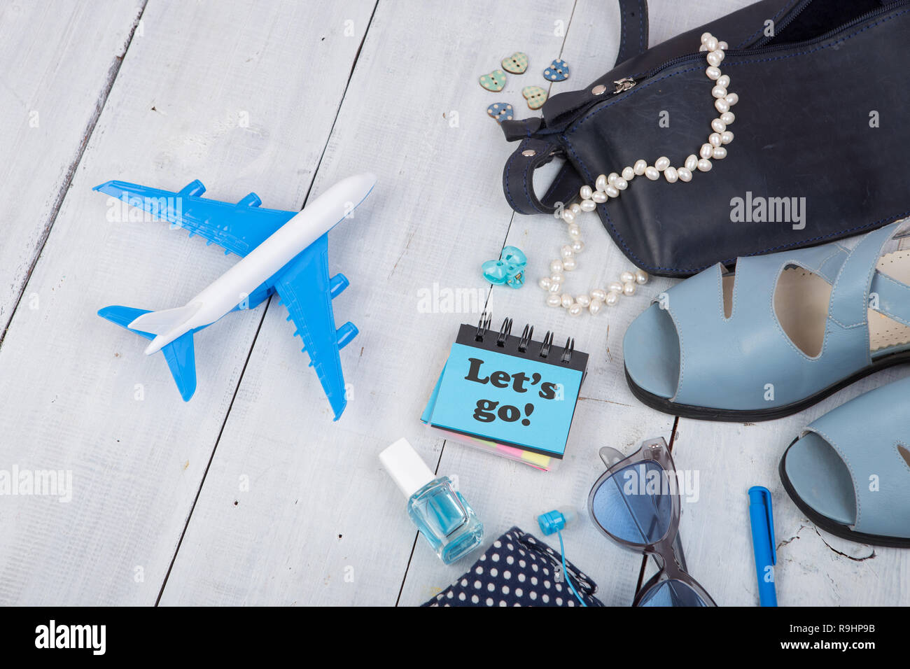 Concepto de viaje - verano la moda femenina con bolsa azul, gafas de sol,  sandalias, esmalte de uñas, auricular notas con el texto \