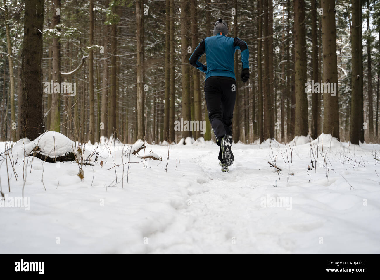 Desde el lado de la imagen del hombre en ropa deportiva, tapa roja en  correr en invierno Fotografía de stock - Alamy