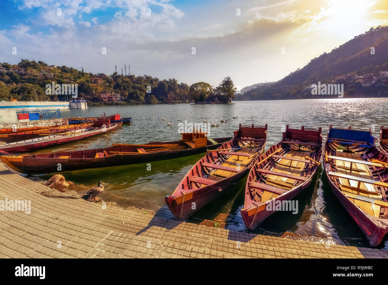 Los barcos turísticos de madera al pintoresco lago Bhimtal en Nainital Uttarakhand India al atardecer con cielo de Moody. Foto de stock
