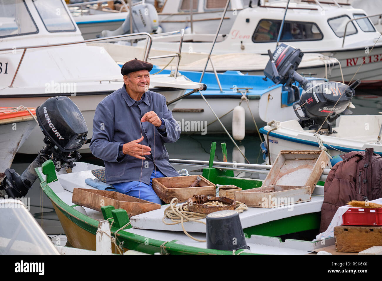 Pescador vistiendo levita y boina en puerto de itinerantes, preparar y  organizar su caja de aborda antes de salir al mar Fotografía de stock -  Alamy