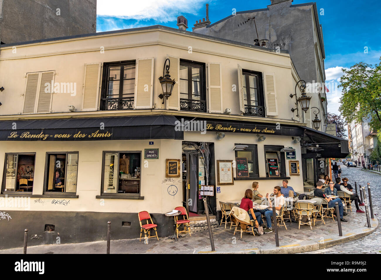 Gente sentada fuera de Le Rendez-Vous des Amis, un café / restaurante en Montmartre, París, Francia Foto de stock