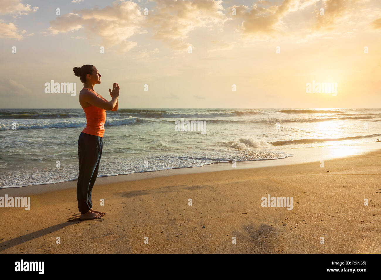 Mujer haciendo yoga en la playa Foto de stock