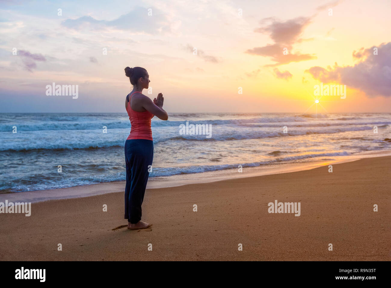 Mujer haciendo yoga en la playa Foto de stock
