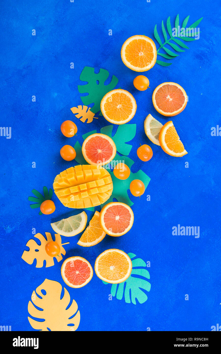 Los cítricos, mangos, naranjas, kumquat, y otras frutas tropicales vibrantes fondo azul con espacio de copia. Frutas exóticas cerca. Foto de stock