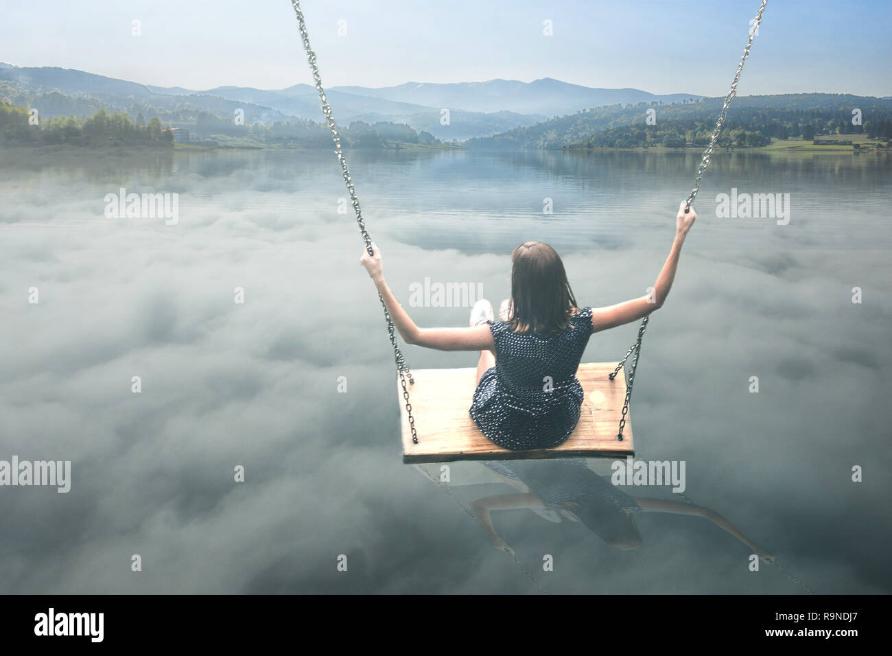 Un niño que está jugando en un columpio por encima de las nubes en una  tierra de fantasía Fotografía de stock - Alamy