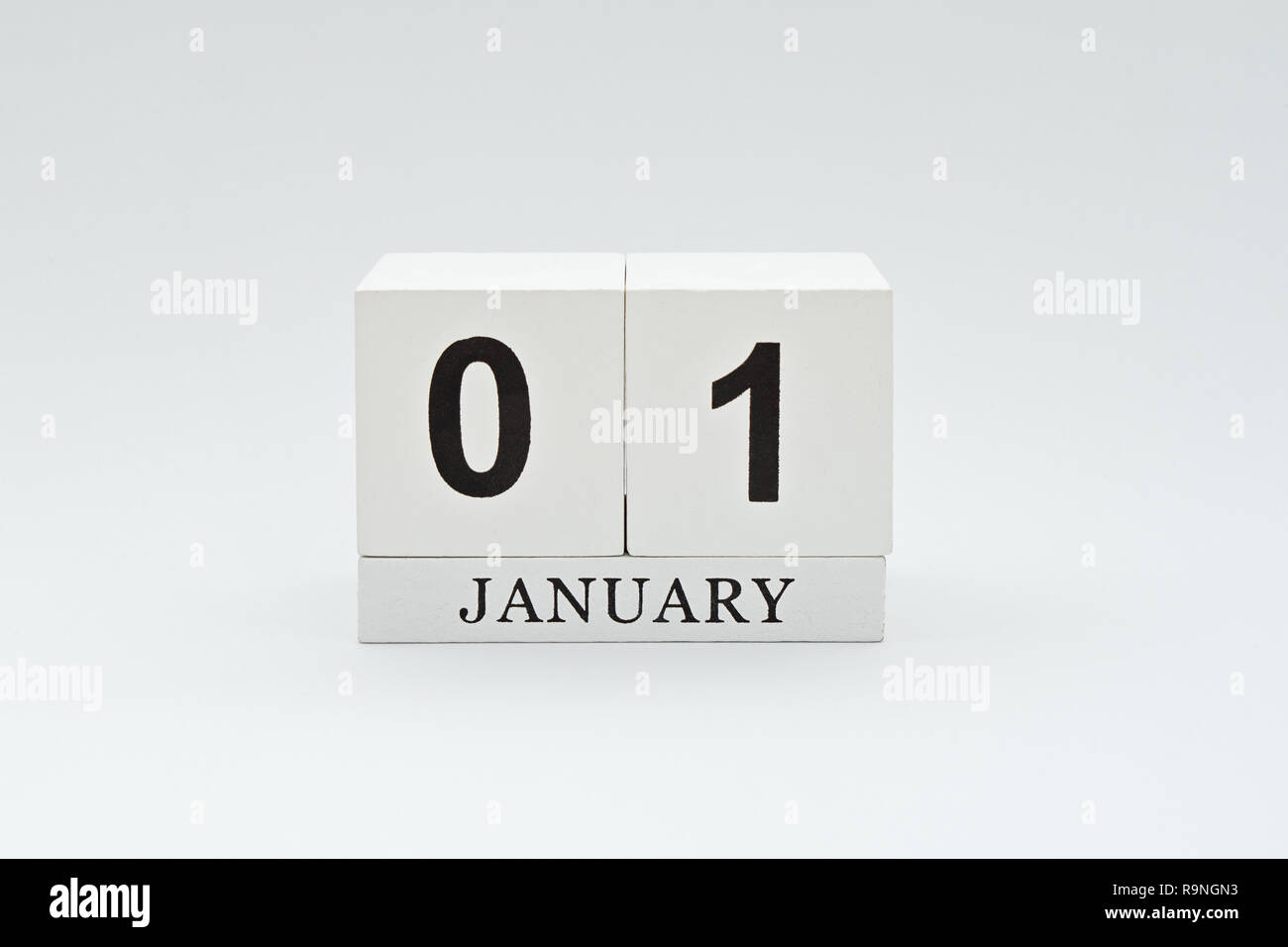 El 1 de enero es el primer día del año nuevo. Calendario vintage de madera  con fecha sobre fondo blanco. Planes e inicios de año nuevo concepto  tributario, hora del día, mini