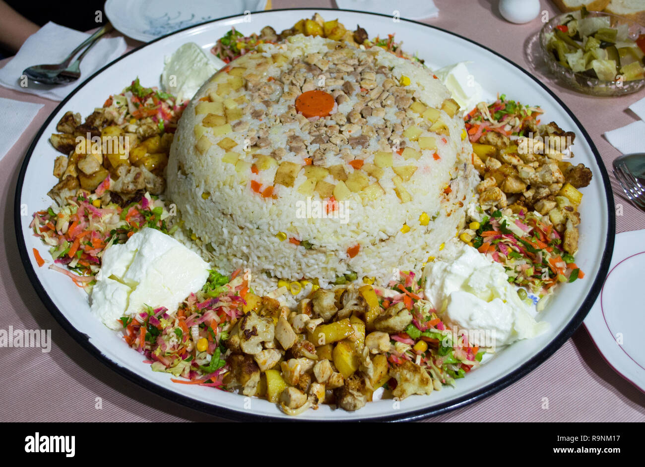Risotto de arroz con carne de pollo, papas, arvejas, zanahoria en rodajas y tomato. Comida tradicional árabe Maqluba Foto de stock