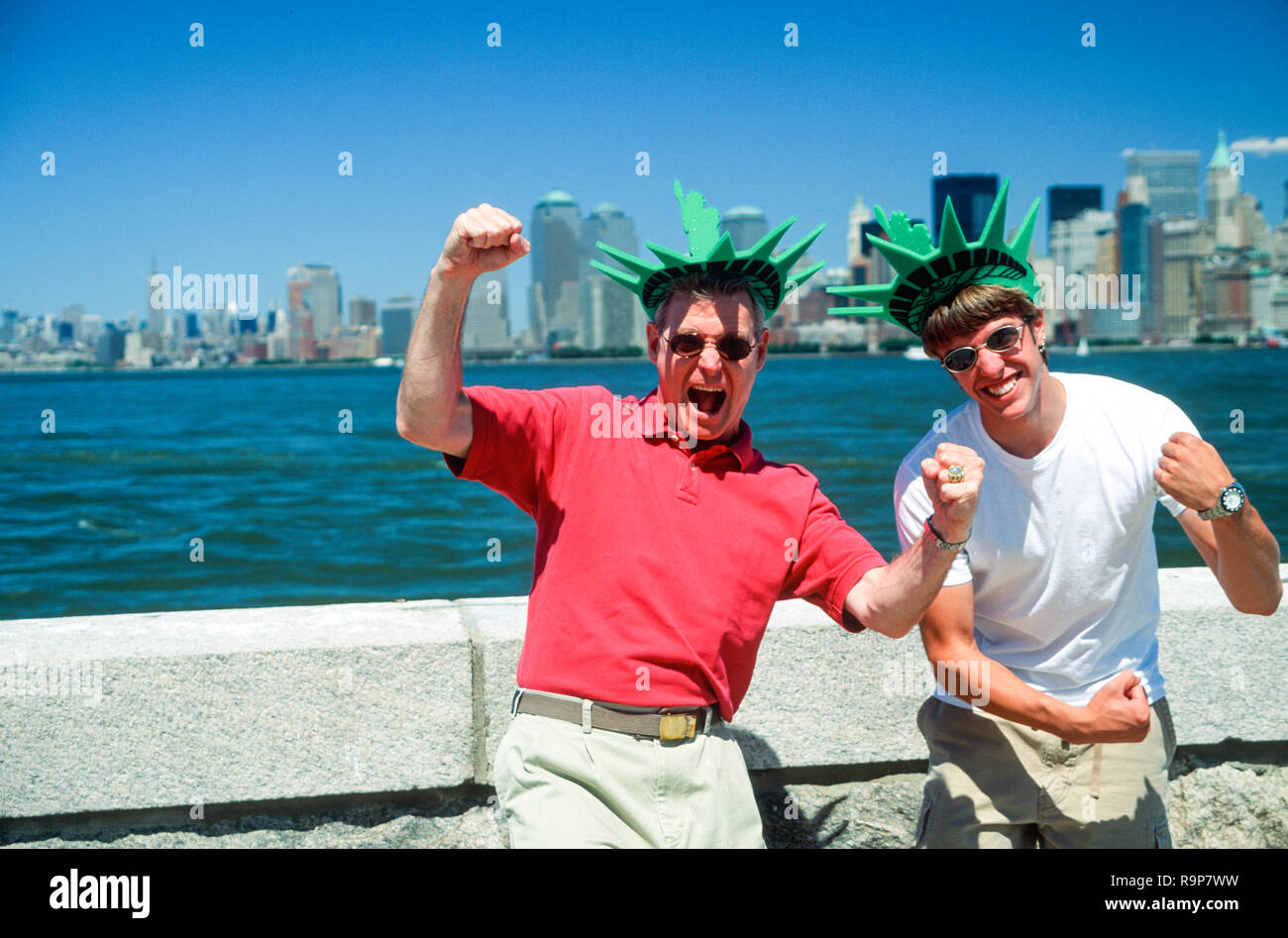 Padre e Hijo turista disfrutando de la isla de Ellis en su espuma coronas de la Estatua de la libertad, de la ciudad de Nueva York, EE.UU. Foto de stock