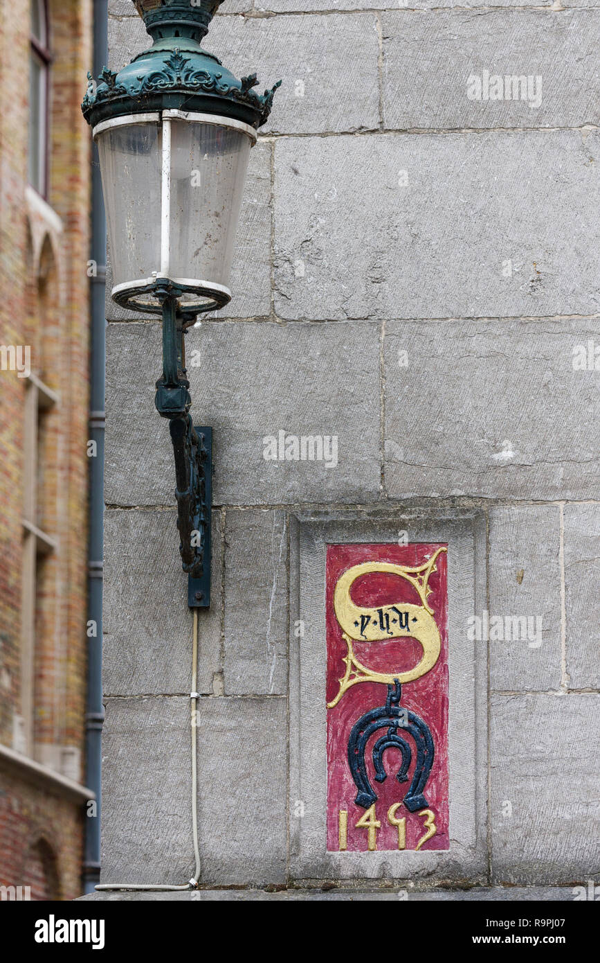 El significado no se ha recuperado de la misteriosa emblema en la fachada de la Huis Ter Beurze en Brujas, Bélgica Foto de stock