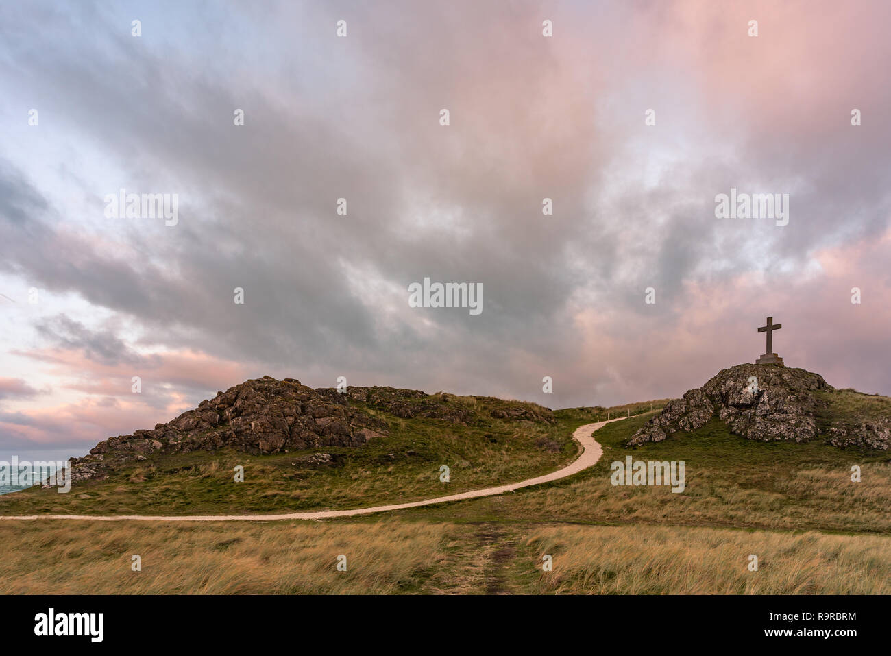 La isla Llanddwyn cruz por Twr Mawr en Ynys Llanddwyn en Anglesey, Gales del Norte al amanecer. Foto de stock