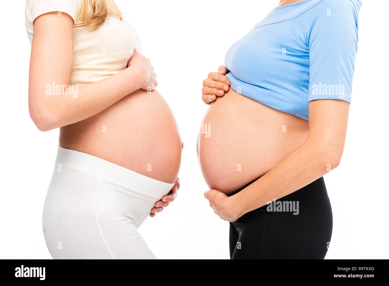 Vista recortada de dos mujeres embarazadas mostrando vientres en perfil  aislado en blanco Fotografía de stock - Alamy