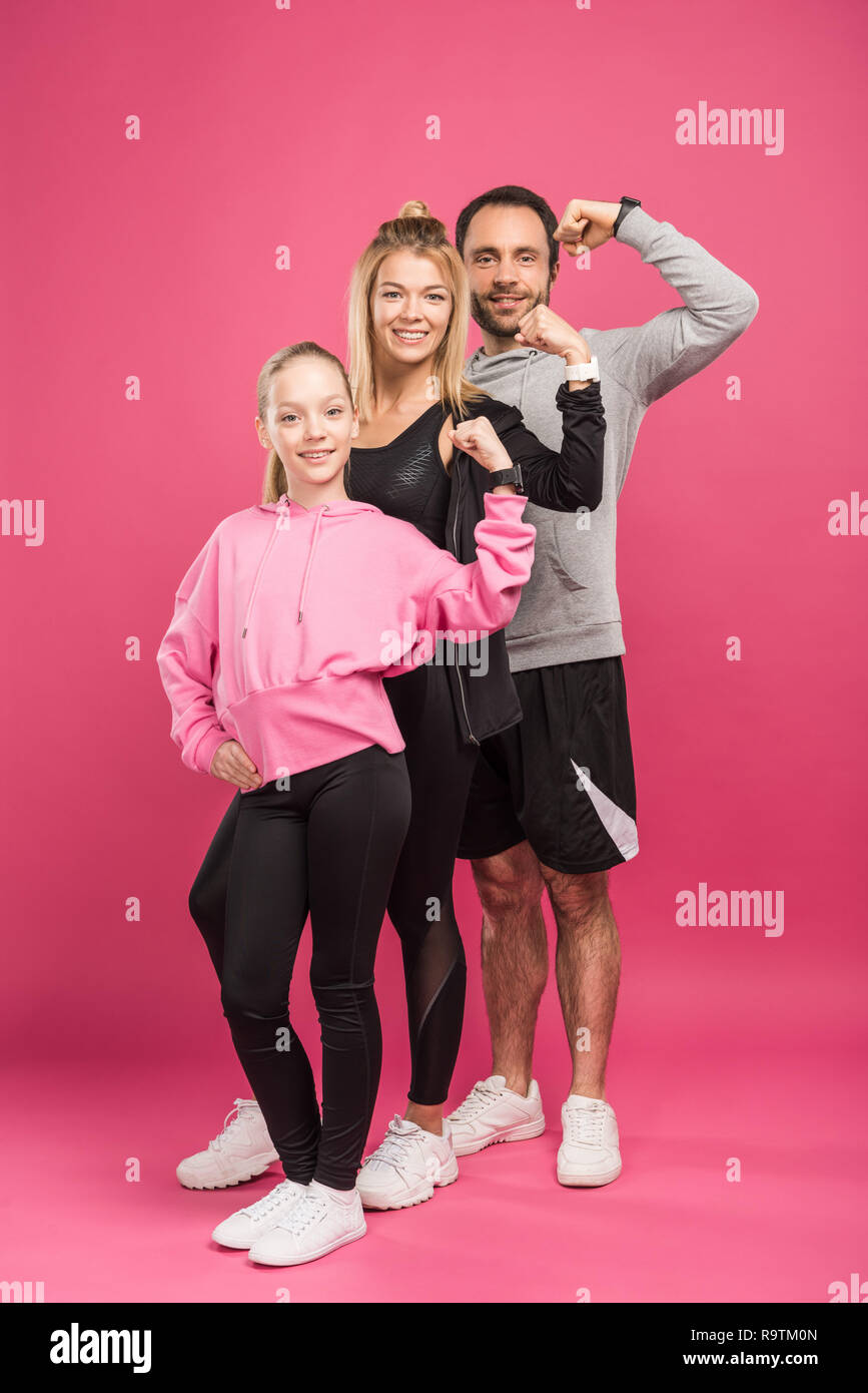 La familia atlética fuerte en ropa deportiva mostrando musculosos bíceps,  aislado en rosa Fotografía de stock - Alamy