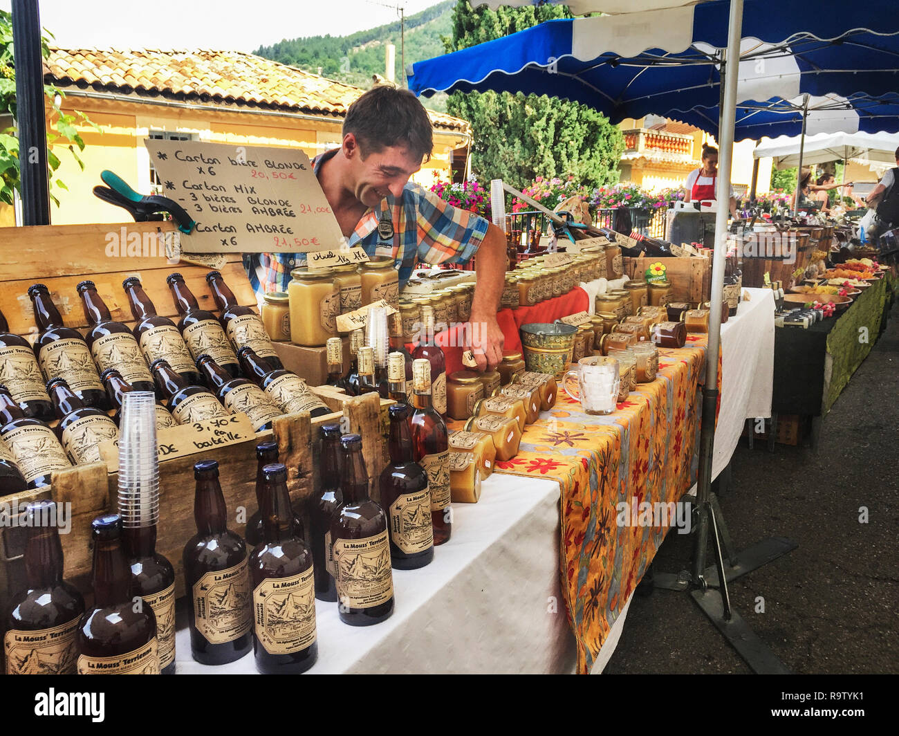 Las cervezas, los alimentos, los productos locales, expuestos para la venta en el mercado de fin de semana, de Moustiers-Sainte-Marie, Provence-Alpes-Côte d'Azur, Francia. Foto de stock