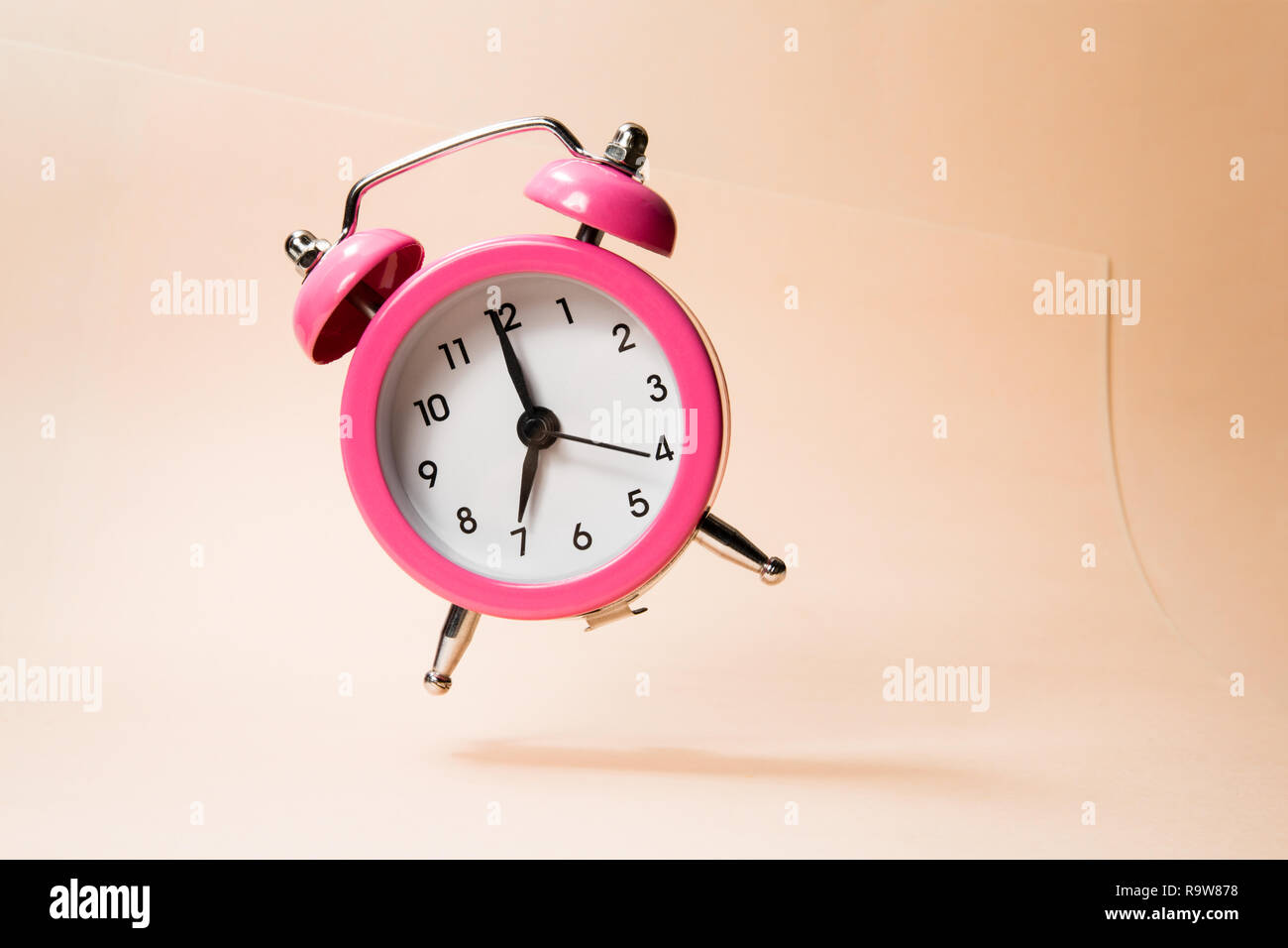 El reloj despertador negro sobre una servilleta de rayas en blanco y negro  mostrando 7 o'clock en una mesilla Fotografía de stock - Alamy
