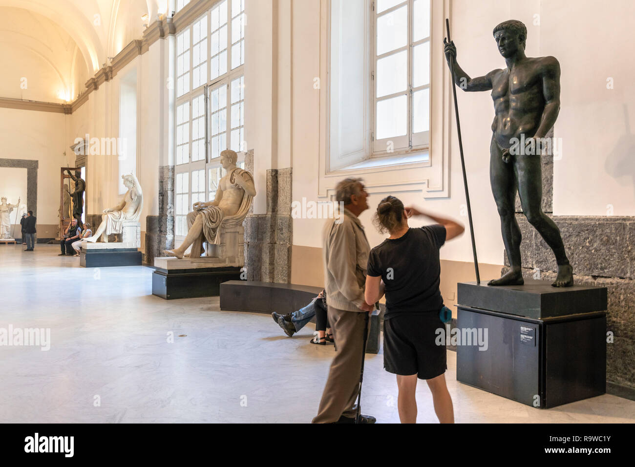 Visitantes que buscan en época romana, esculturas en el Museo Arqueológico Nacional en Nápoles, Italia. Foto de stock