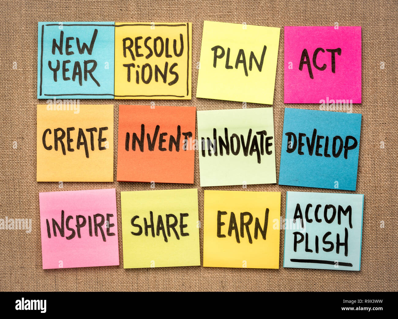 Resoluciones de año nuevo inspirador en notas adhesivas: planificar, actuar, crear, inventar, innovar, desarrollar, motivar, compartir, lograr ganar. Foto de stock