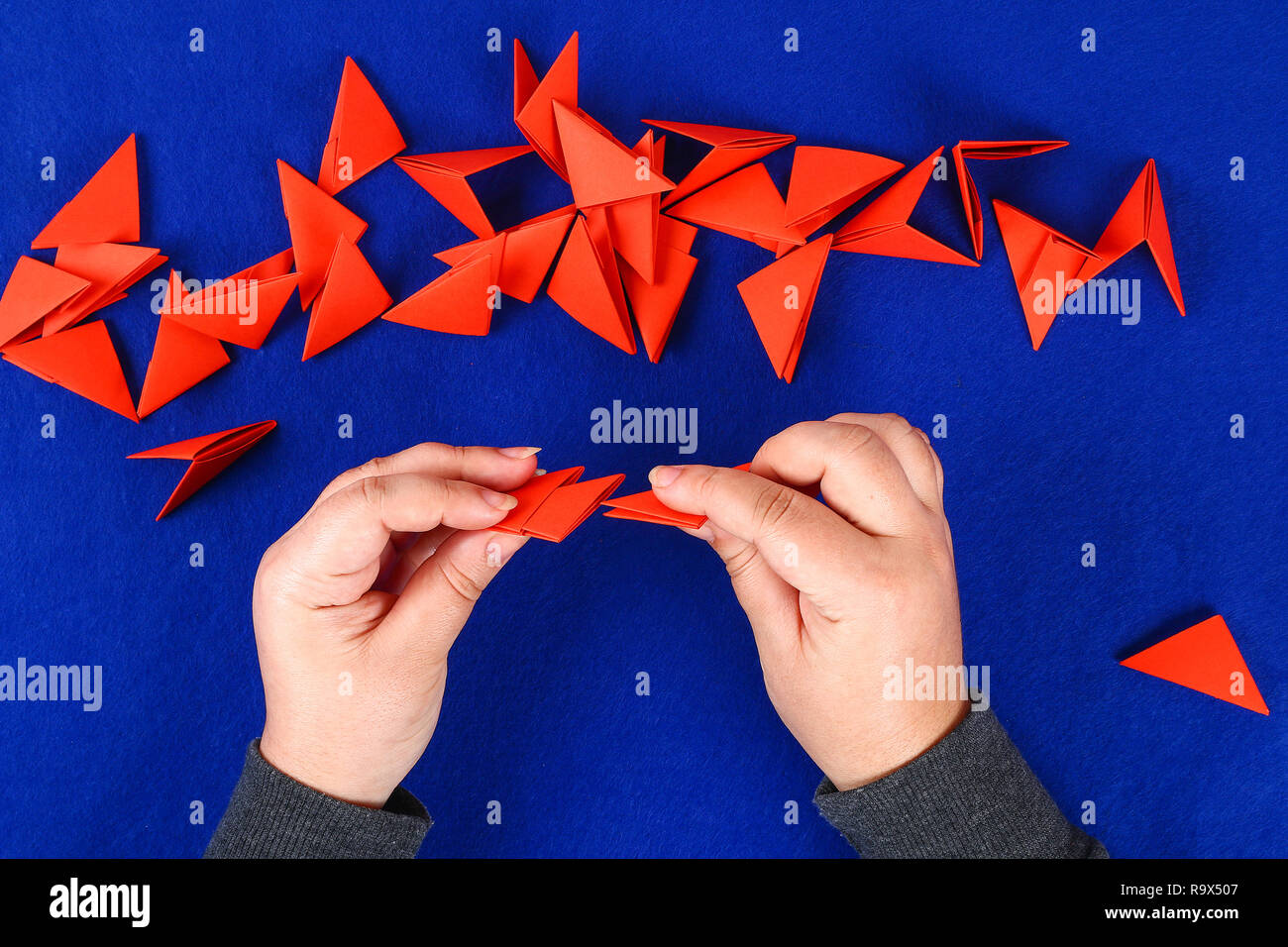 Bricolaje dragón chino sobre fondo azul. Ideas para regalo, decoración de Año Nuevo Chino. Artesanal de oro rojo dragón lunar león de origami modular. Paso a paso. El Foto de stock