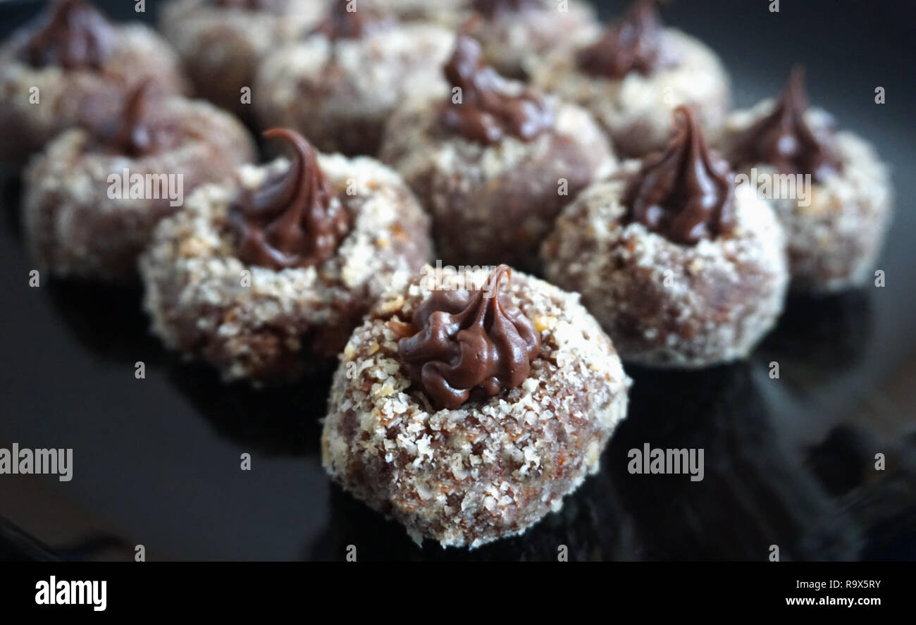 Preparamos un delicioso chocolate praliné decorado con avellana rallada sobre la placa negra Foto de stock