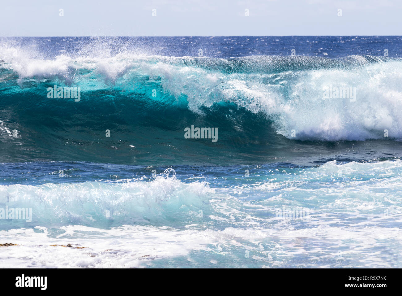 Ola rompiendo cerca de la costa en el South Point, en la isla más grande de Hawai. Espuma de mar en primer plano. Foto de stock
