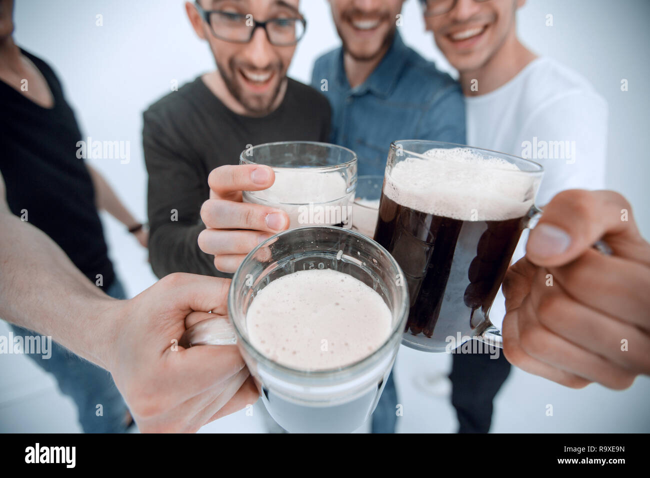 Close up.jarras de cerveza en las manos de un grupo de hombres Foto de stock