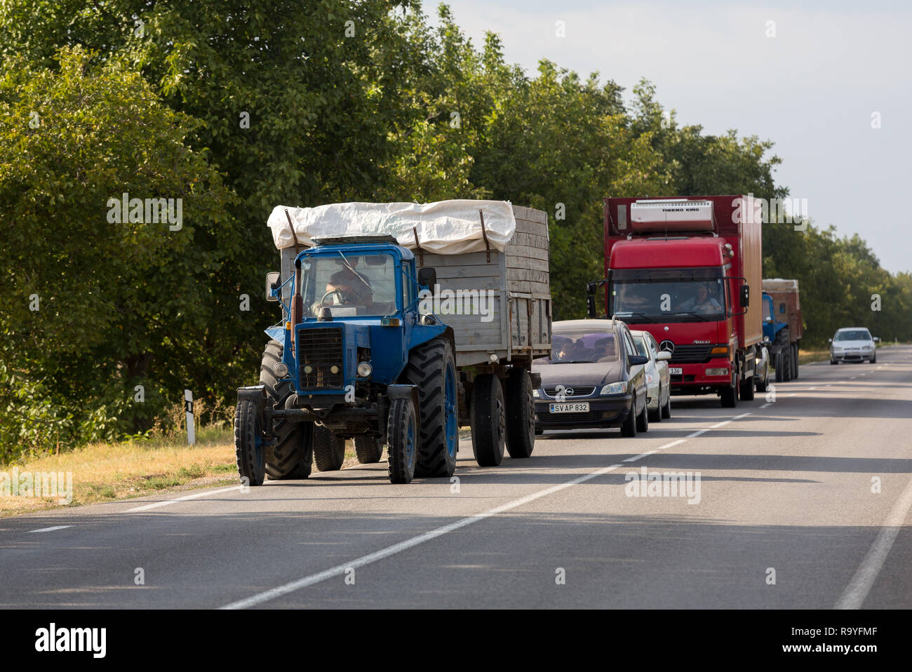 30.8.2016, Olanesti, Rajon Stefan Voda, Republik Moldau - Bauer mit Traktor transportiert Erntegut. Dahinter stauen sich andere Fahrzeuge. 00A160830D Foto de stock