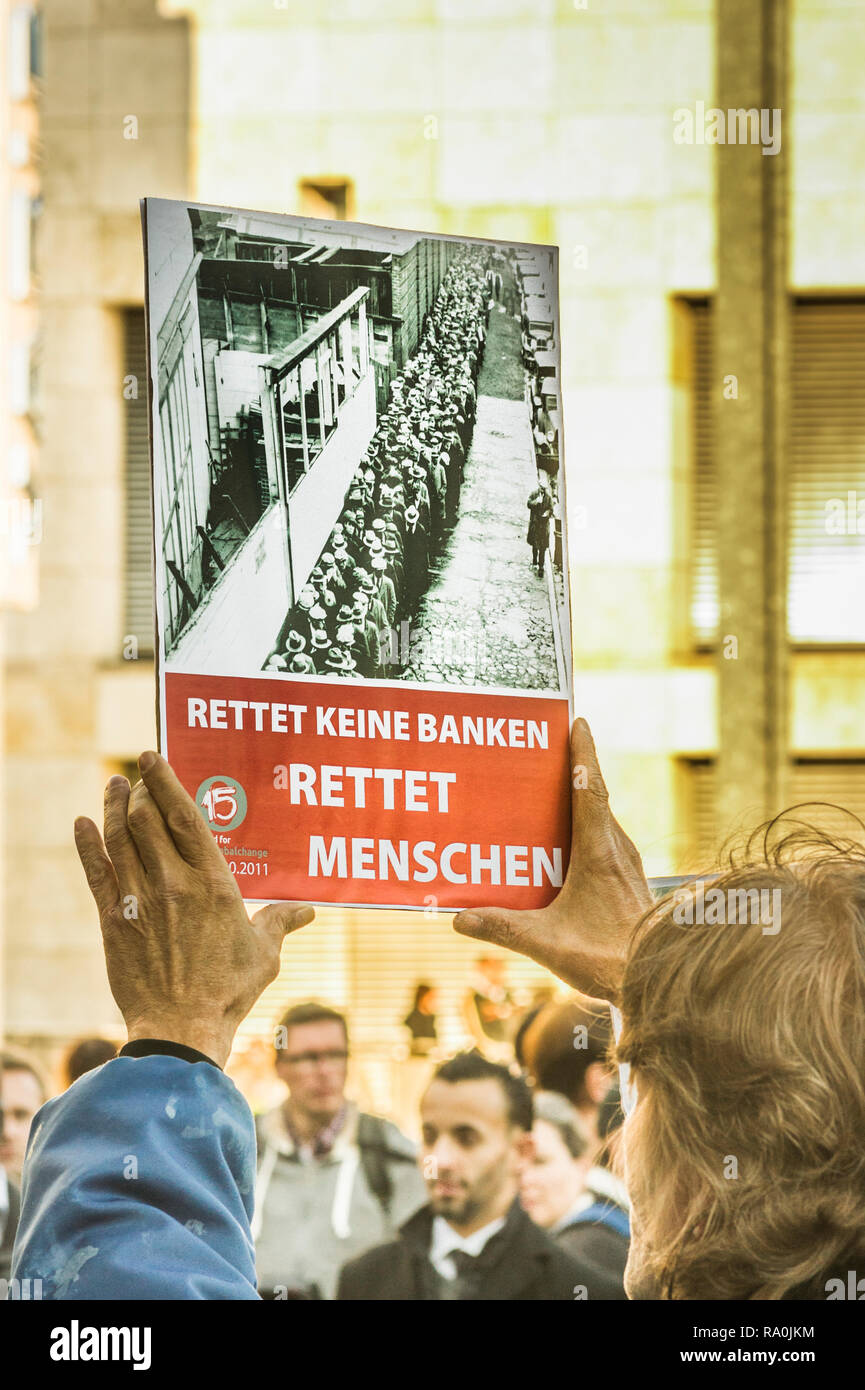Joven sosteniendo un cartel con un texto que dice:   no guardar los bancos, salvar seres humanos  , manifestación contra la especulación financiera Foto de stock