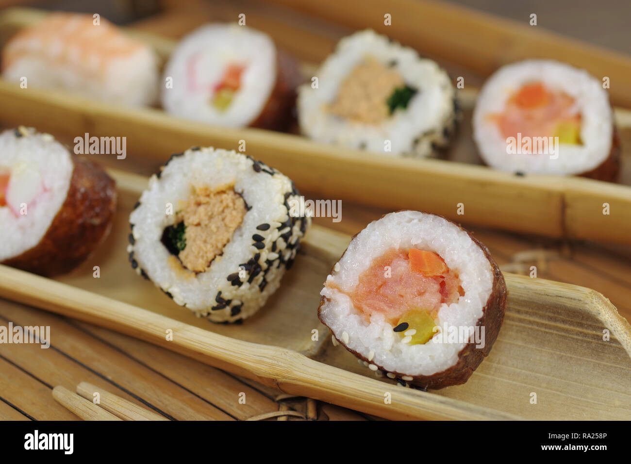 Porción de sushi y la madera en la placa hopsticks Foto de stock