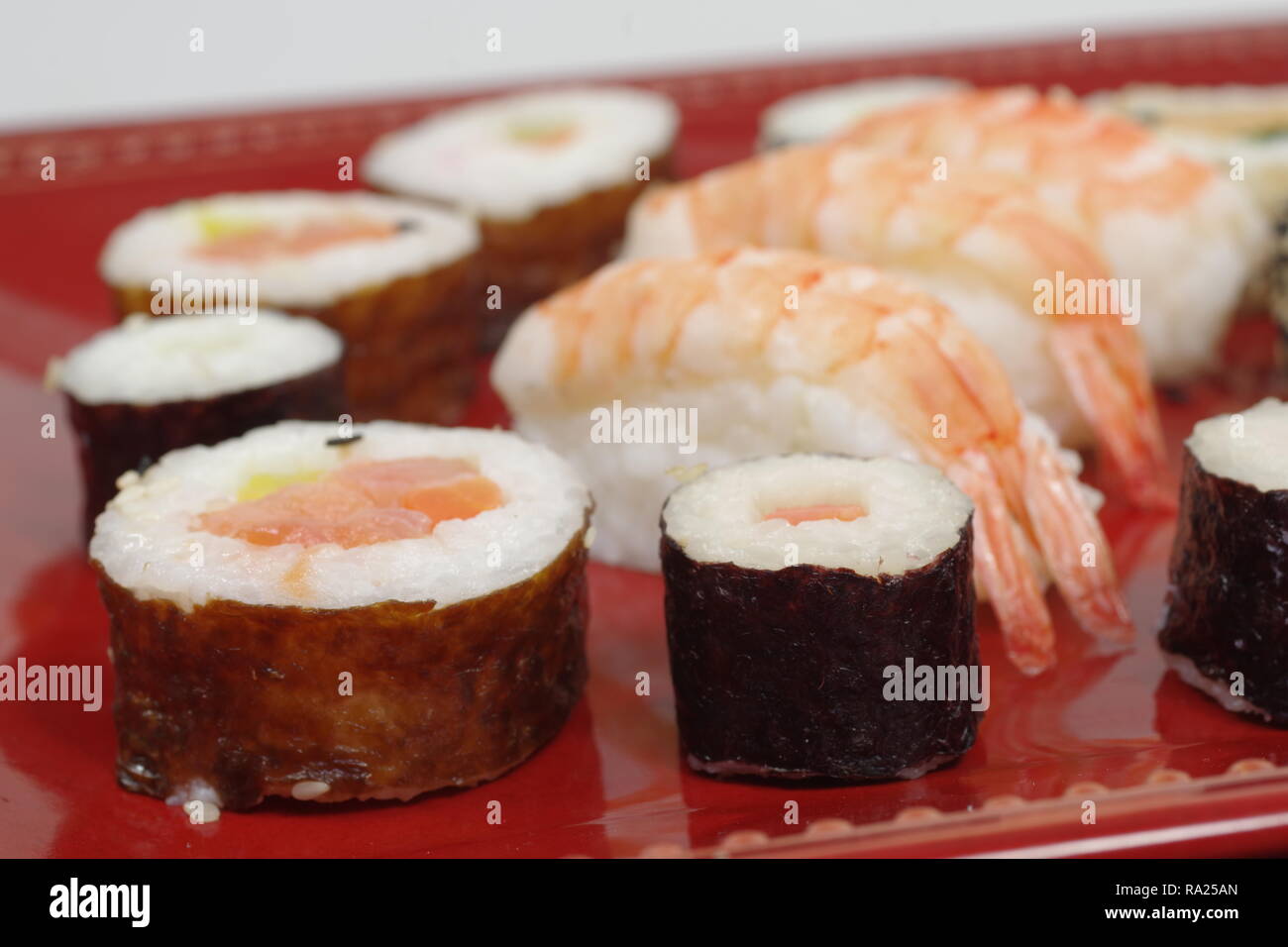 Porción de sushi y la madera en la placa hopsticks Foto de stock